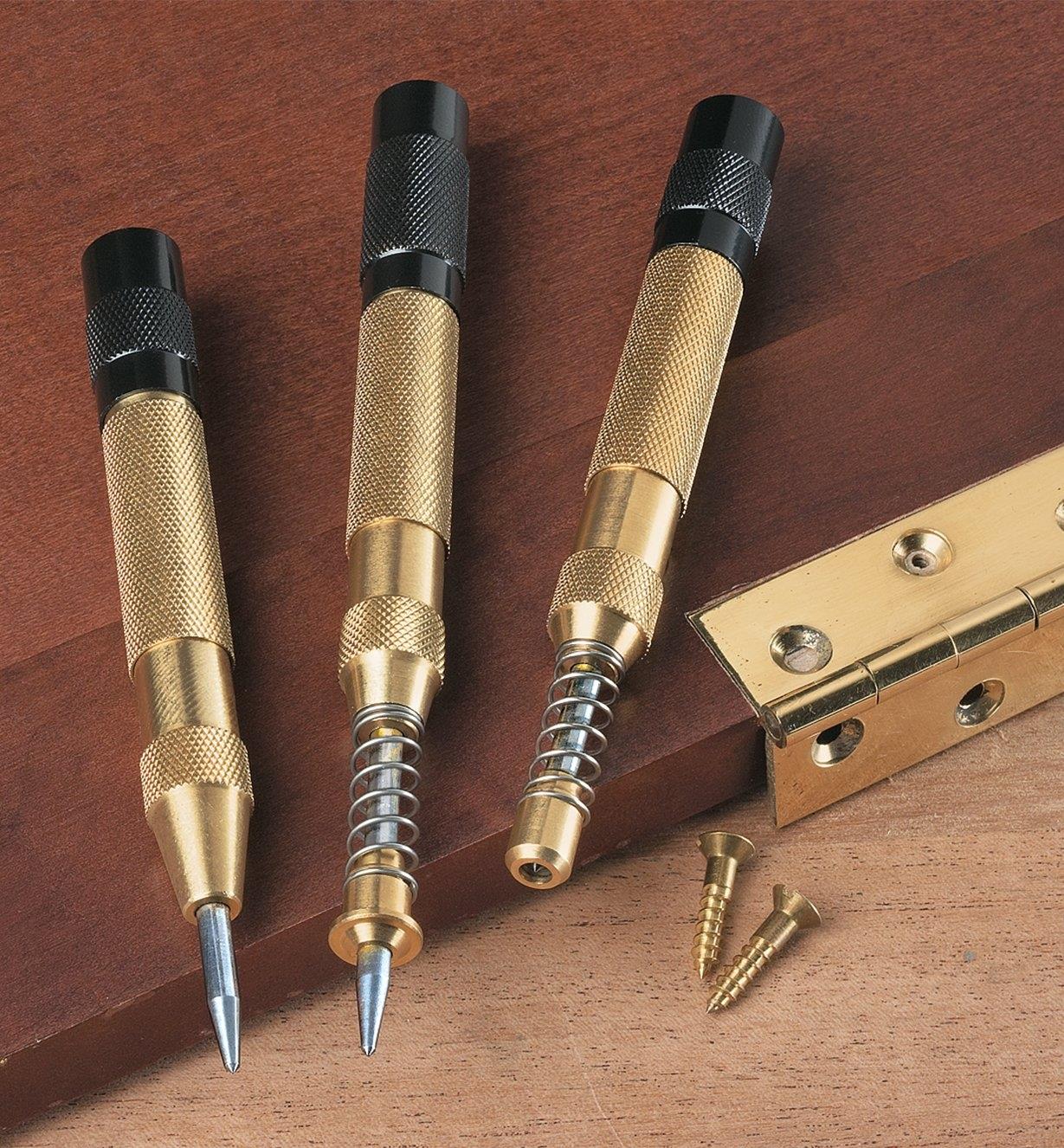 Set of 3 Punches lying on a door with a hinge that is about to be installed