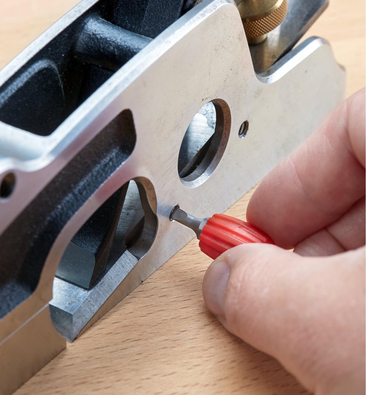 Adjusting a setscrew on the side of a hand plane with a bit in the Utilitas fingertip screwdriver