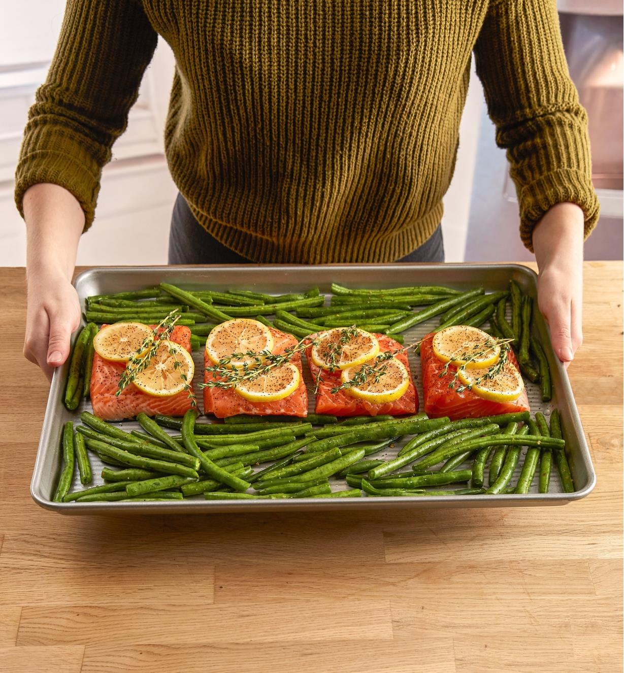 Half sheet baking pan containing salmon pieces and string beans