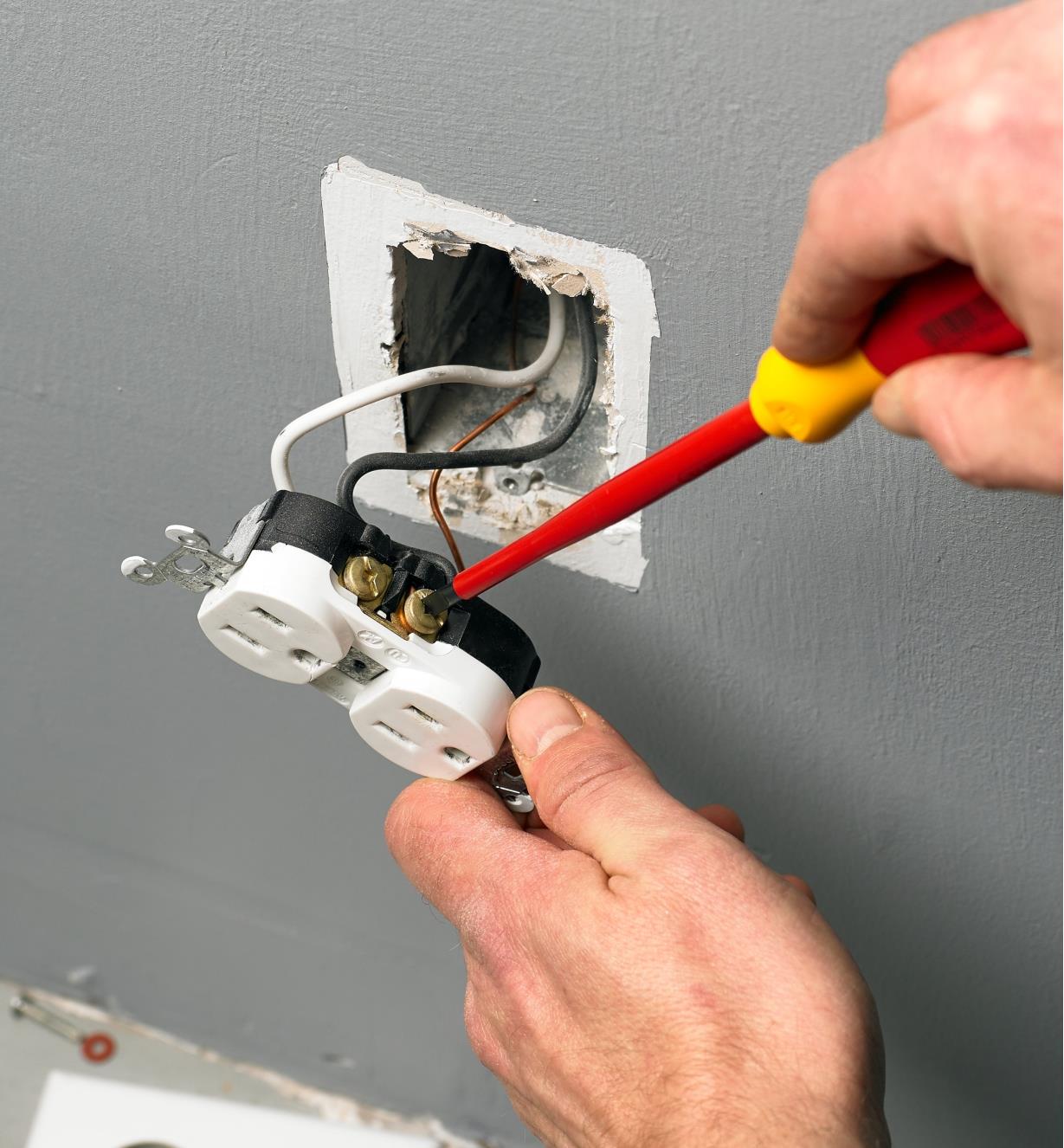 Fixing an electrical outlet with a Wiha insulated screwdriver