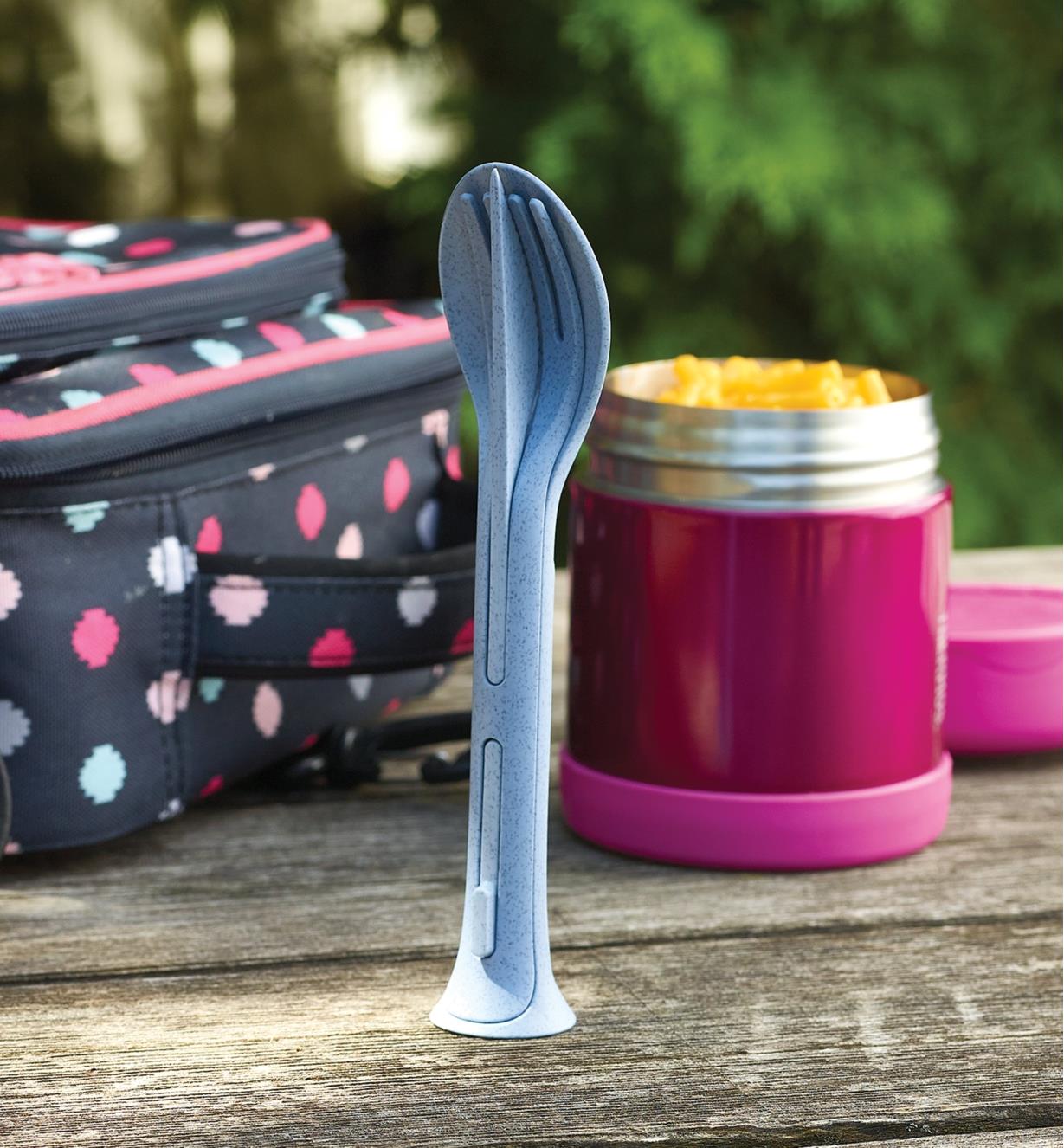 Blue Klikk small cutlery set standing on its end next to a thermos of macaroni and cheese