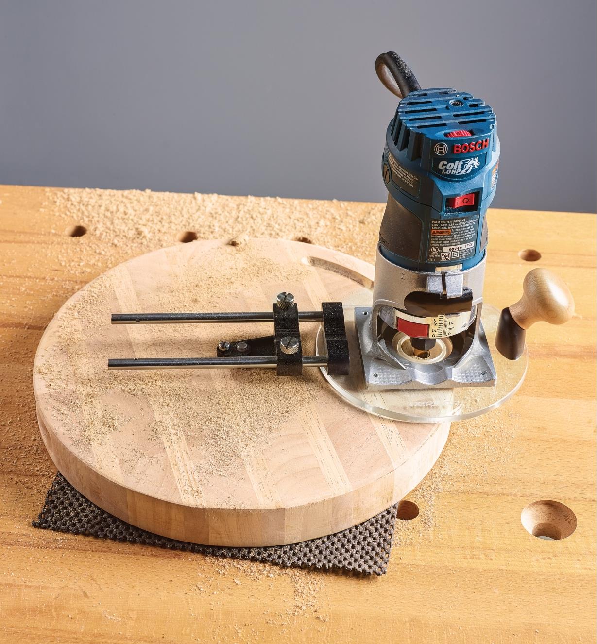 Guide de coupe circulaire fixé à une toupie compacte pour tailler un cercle dans une pièce de bois