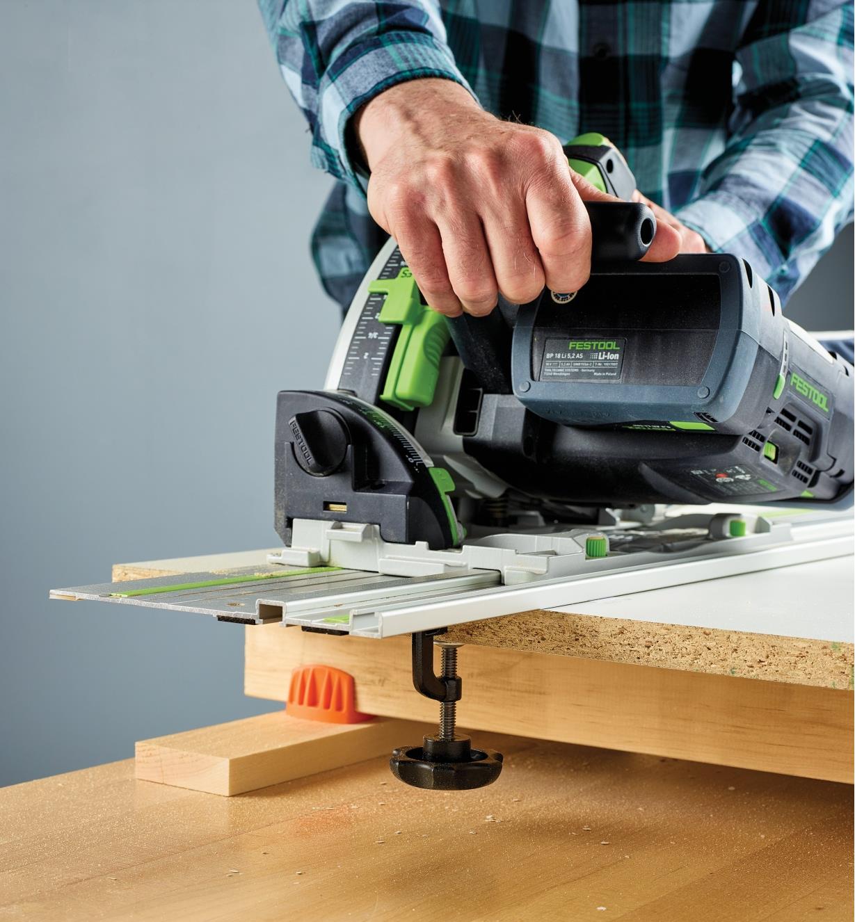Cutting particleboard with a track saw on a track-saw guide held in place by track-saw guide clamps