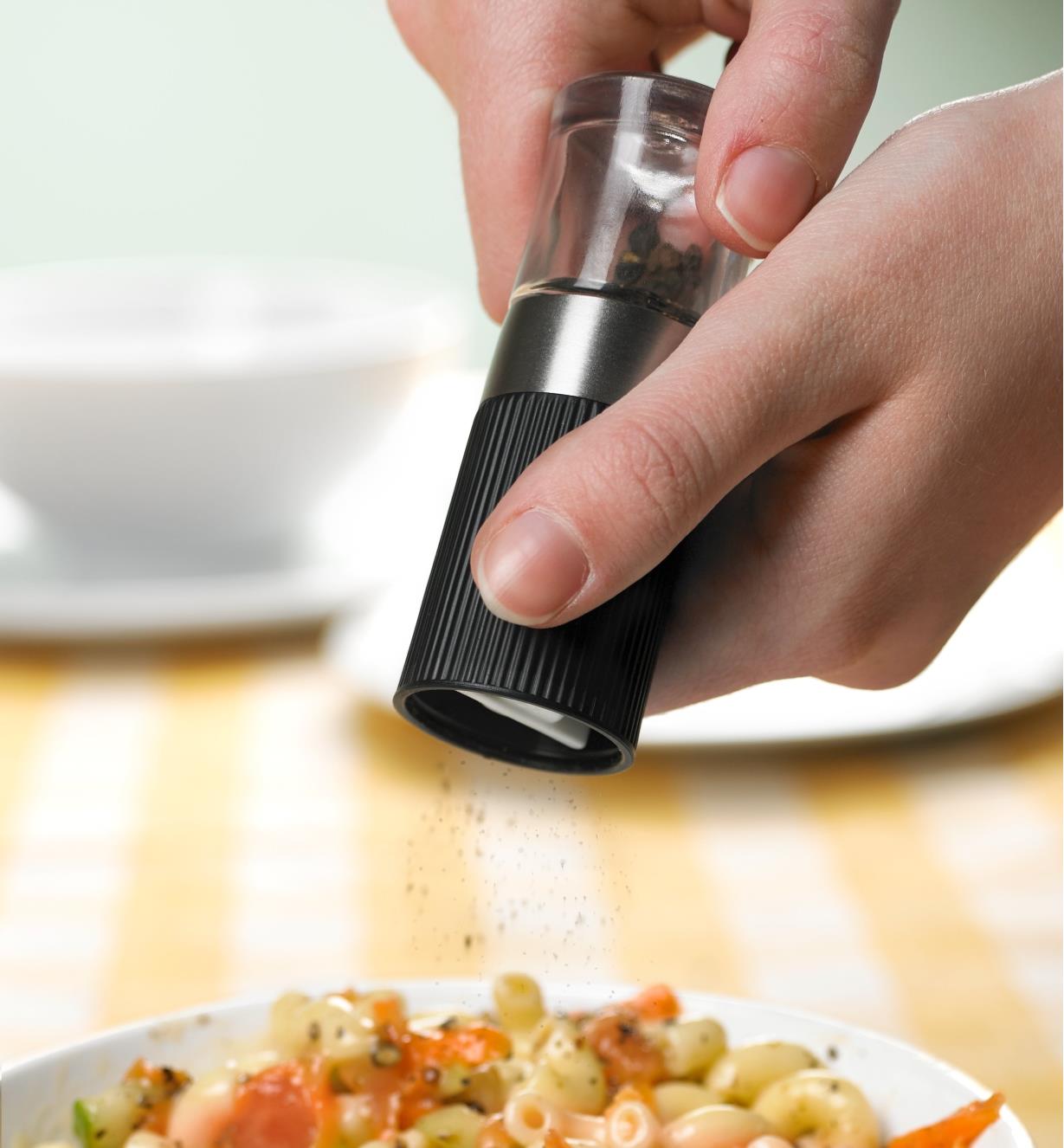 Adding pepper to a dish with the mini pepper grinder