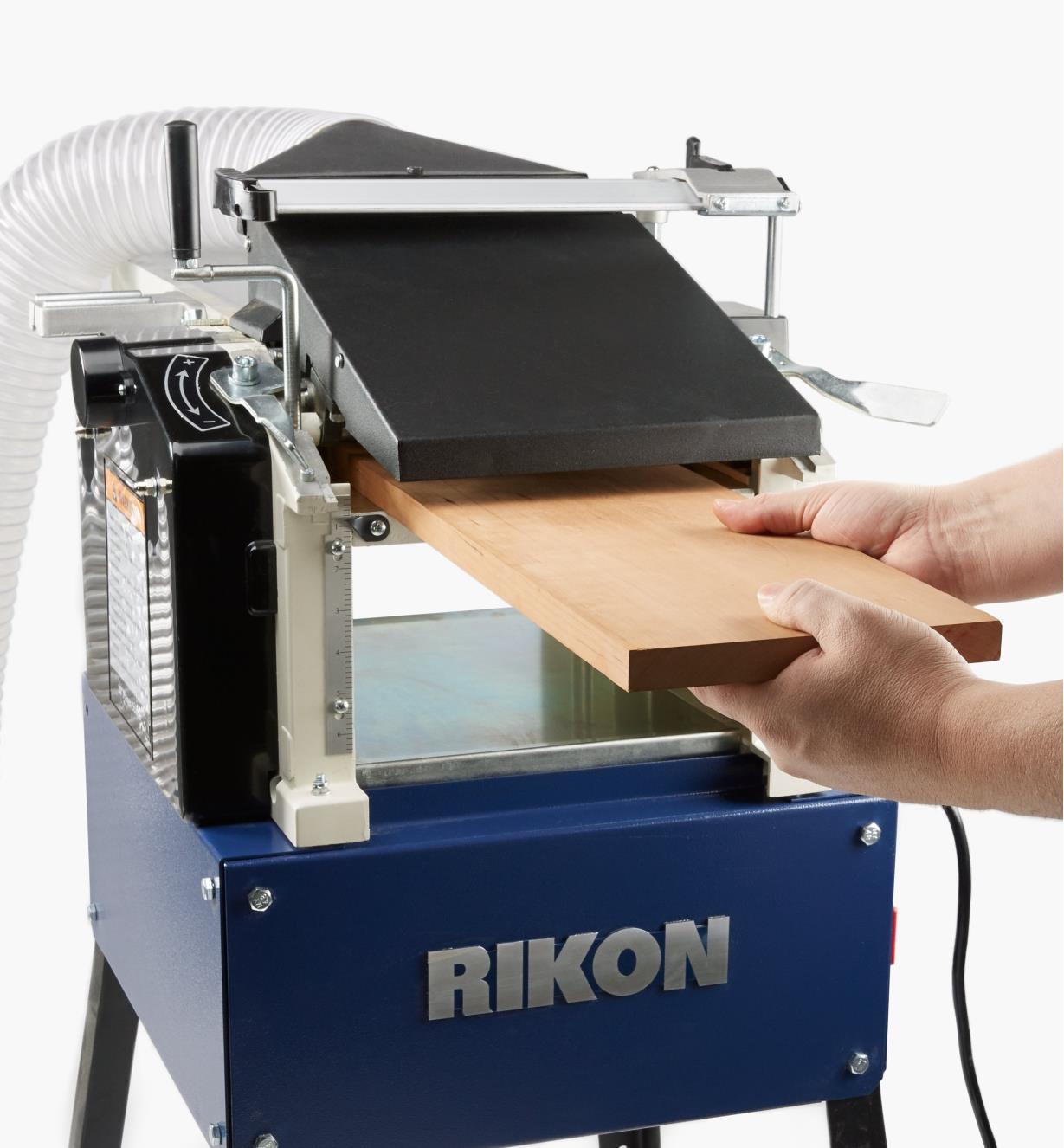 A woodworker feeds stock into the Rikon 10" helical planer/jointer