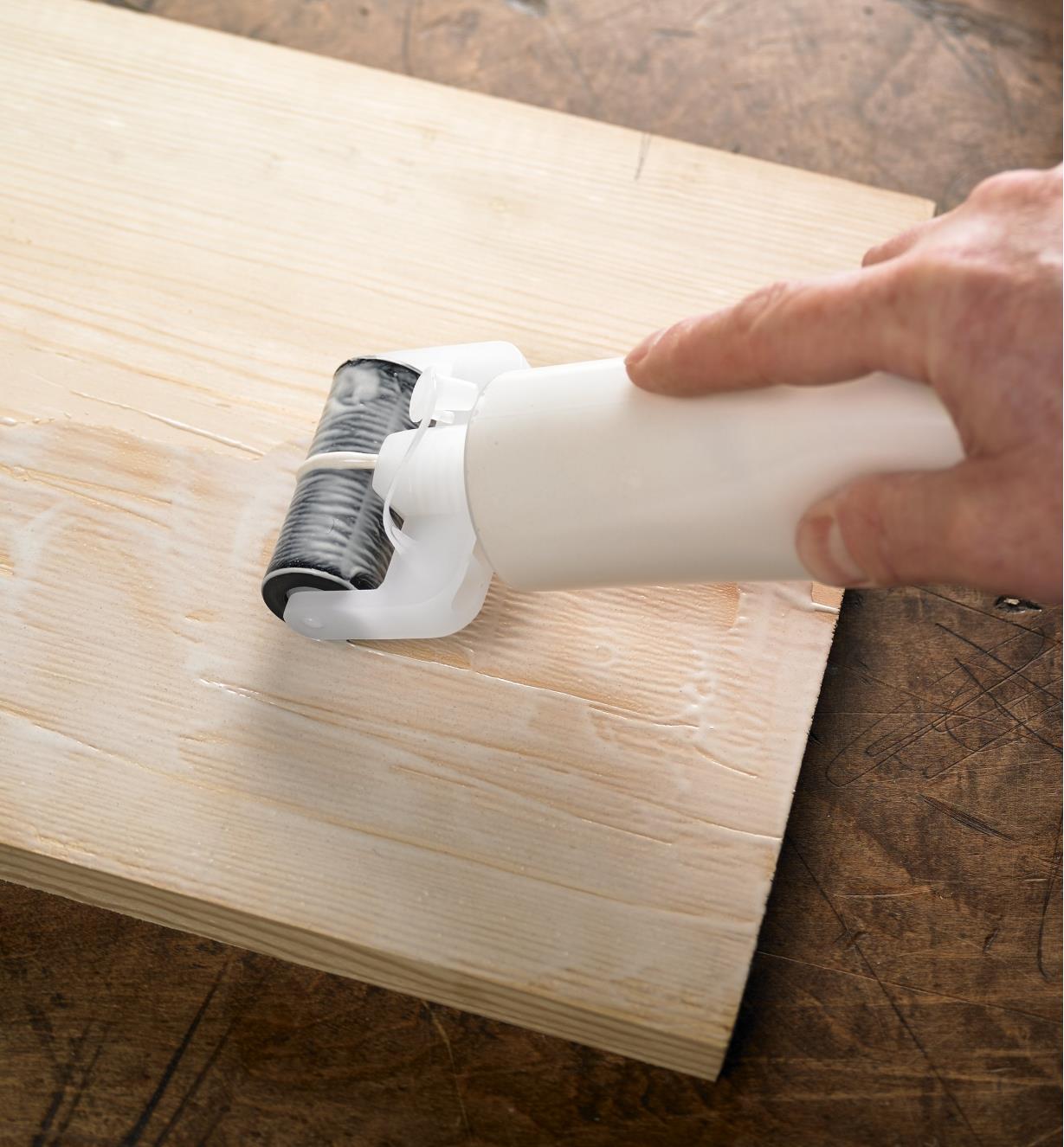Spreading glue onto a board with the Roller Glue Applicator