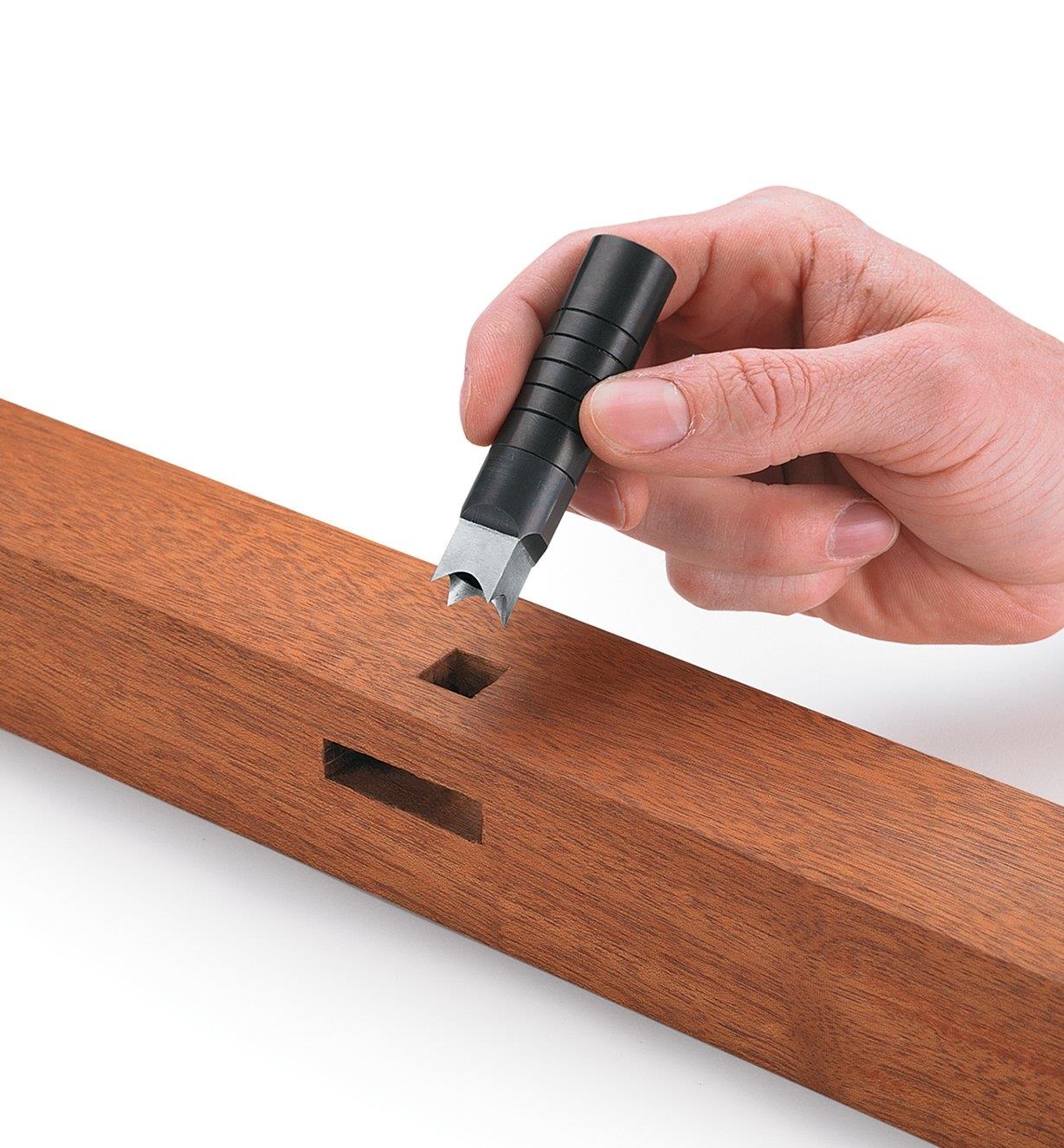 Using a square hole punch to make a square hole in wood