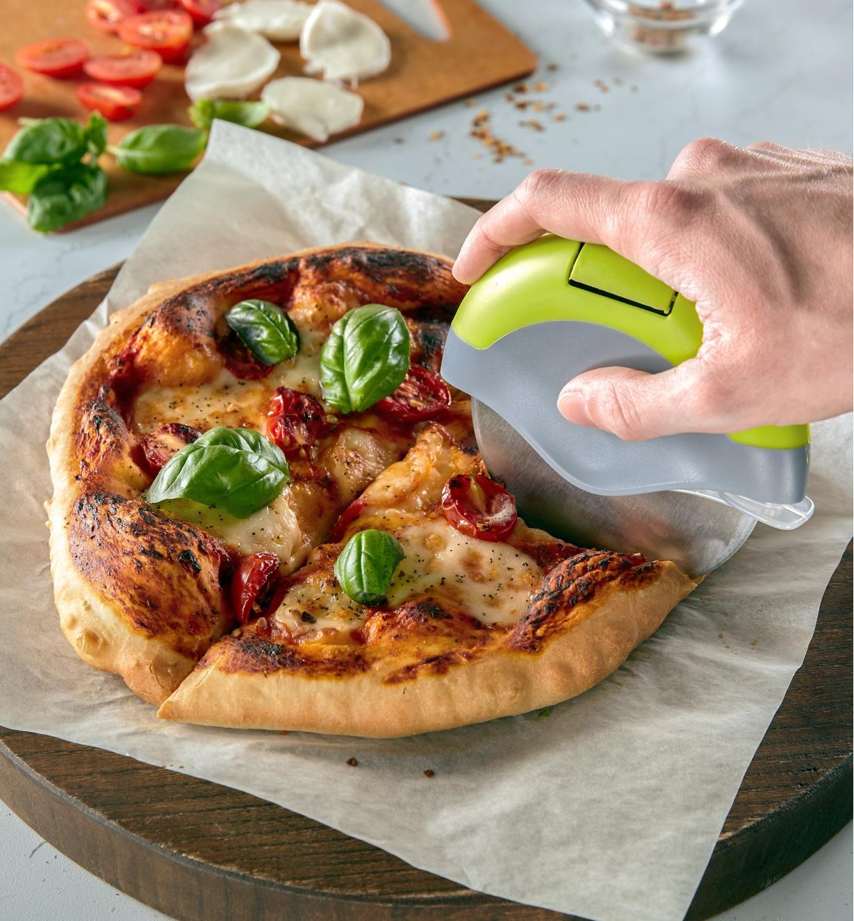 Pizza cutter slicing a cooked pizza