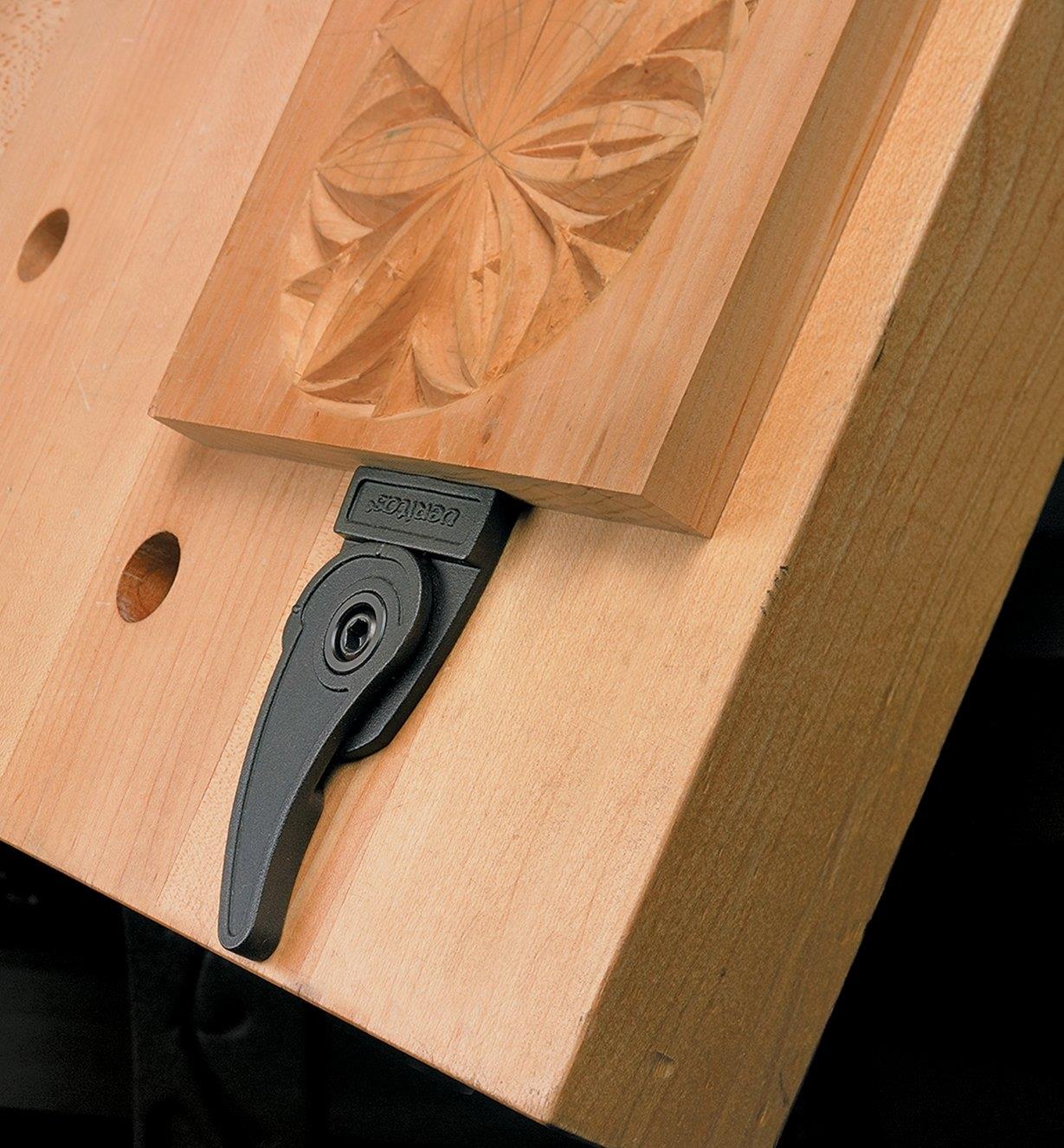 Bench blade holding a relief carving on a near-vertical work surface