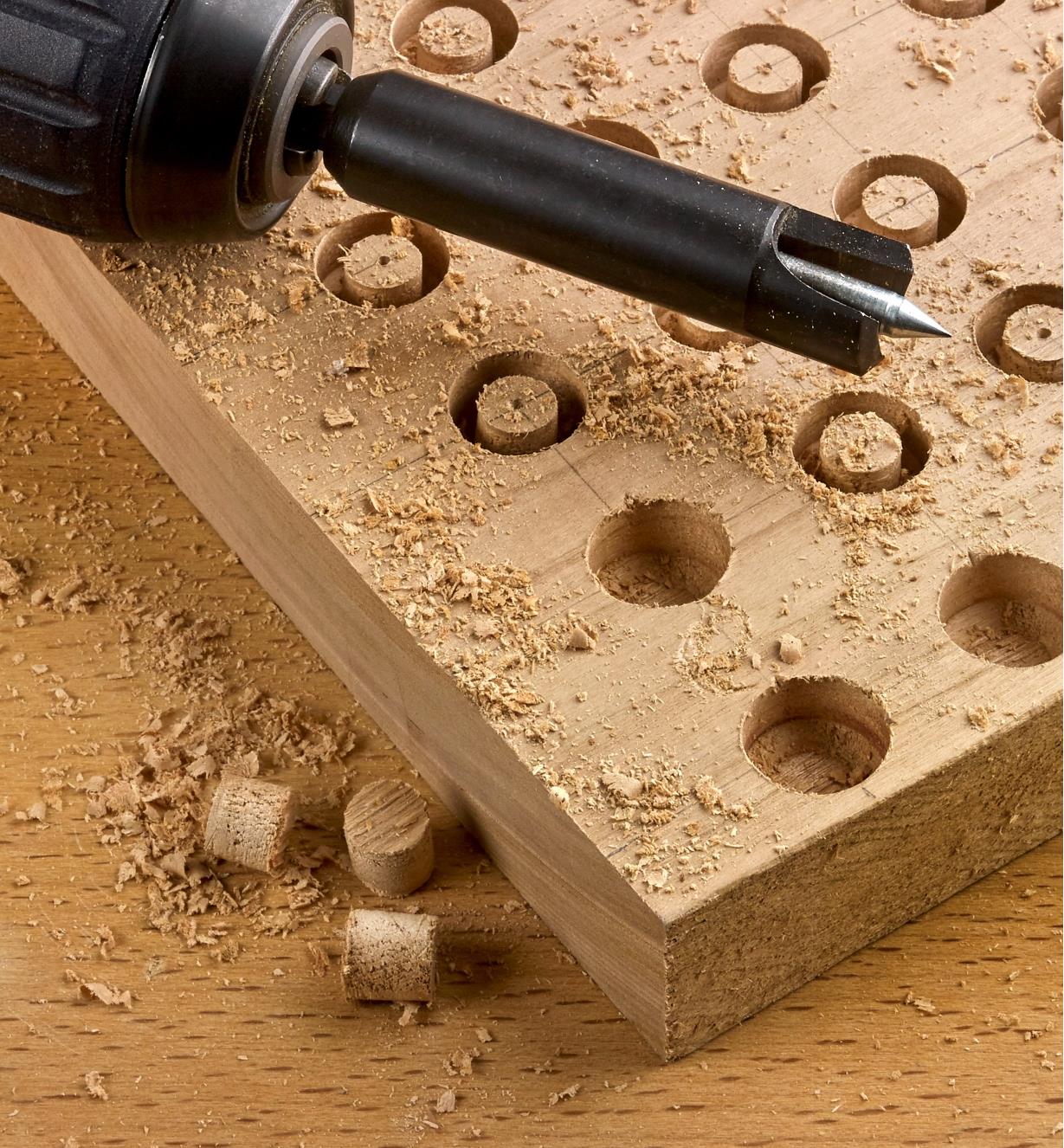 One of the self-centering plug cutters chucked in a drill, used to cut several wooden plugs