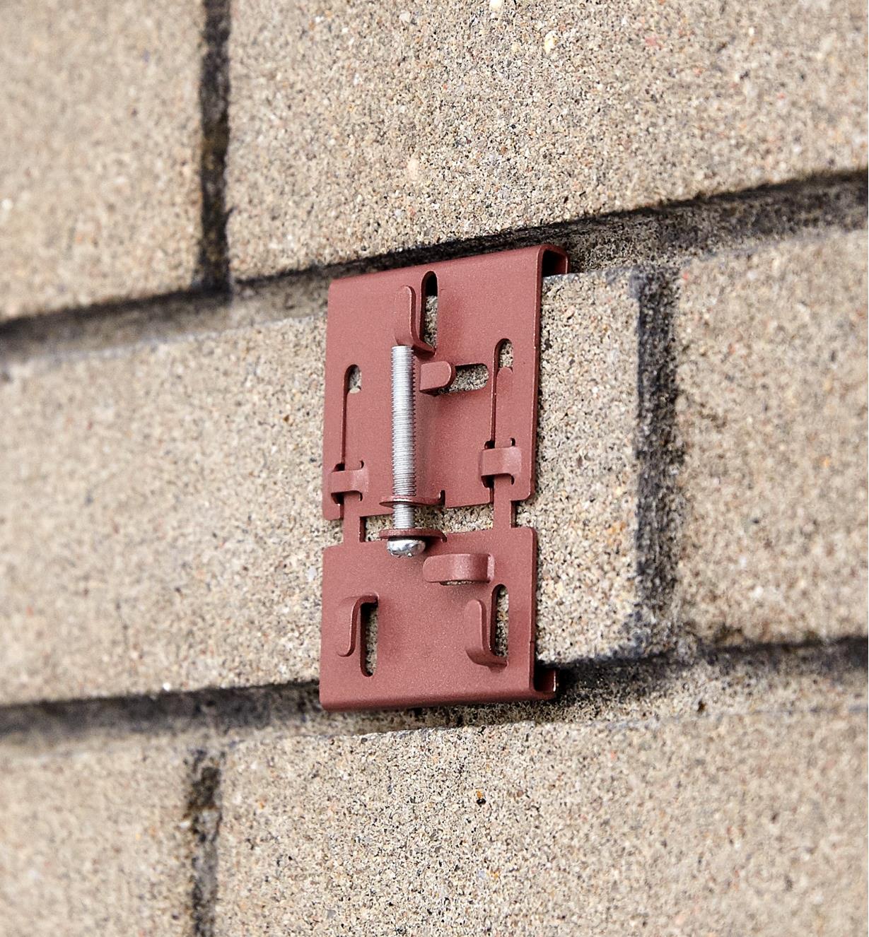 Brick clamp attached to brickwork that has recessed mortar