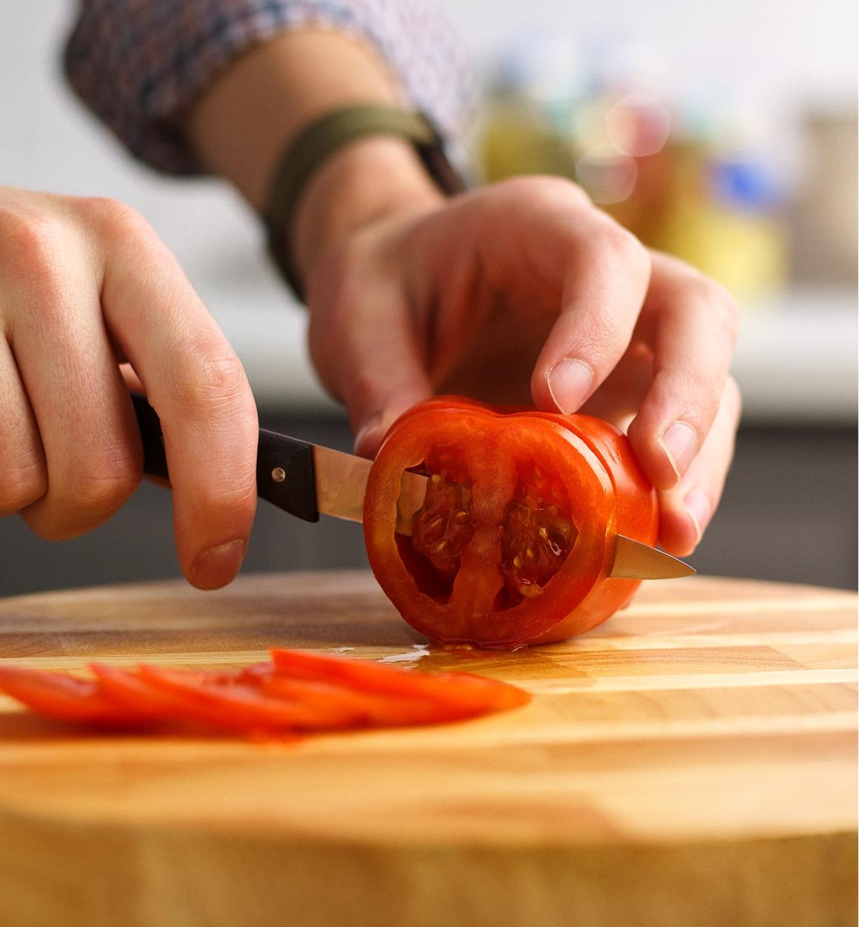 Couteau à légumes à dents ultra-fines tranchant une tomate