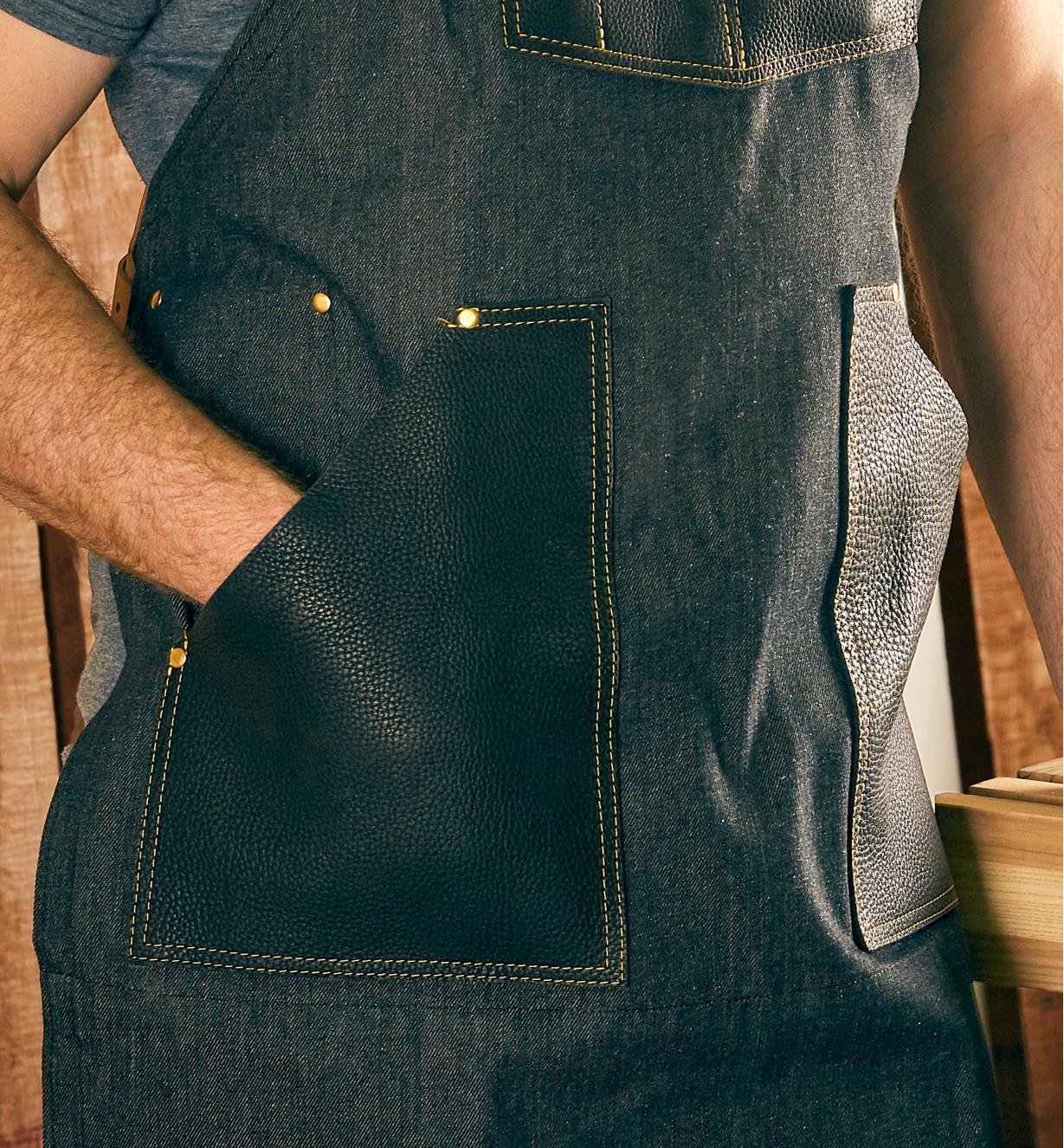 A hand in one of the All-Purpose Apron’s lap pockets
