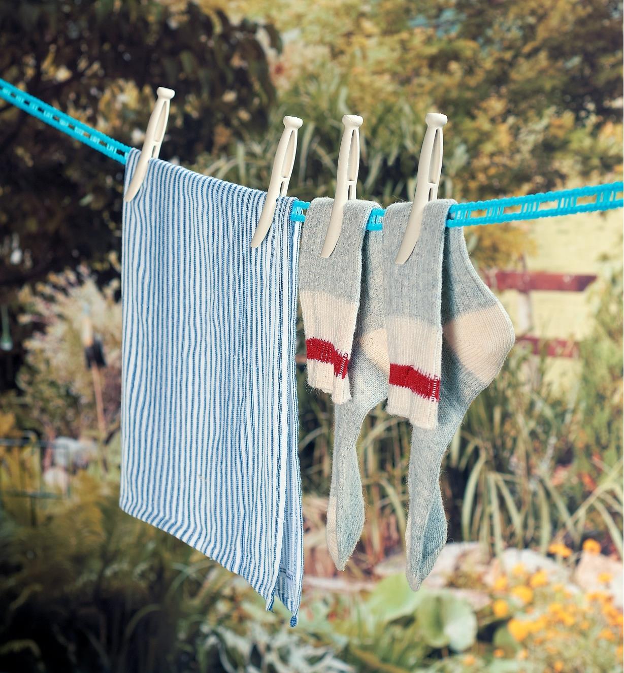 A pair of socks and a towel held on a clothesline with Grandma’s Clothespins