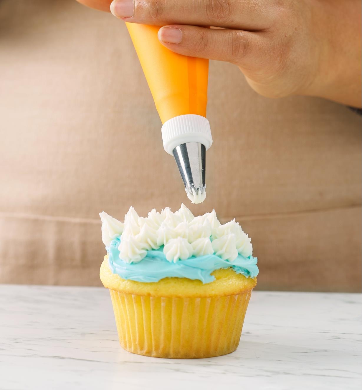 Decorating a cupcake using the piping bag and an icing tip