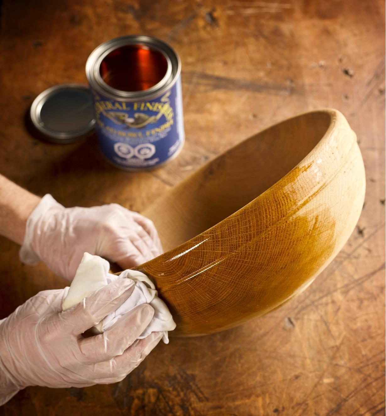 Applying General wood bowl finish by hand to a wooden bowl