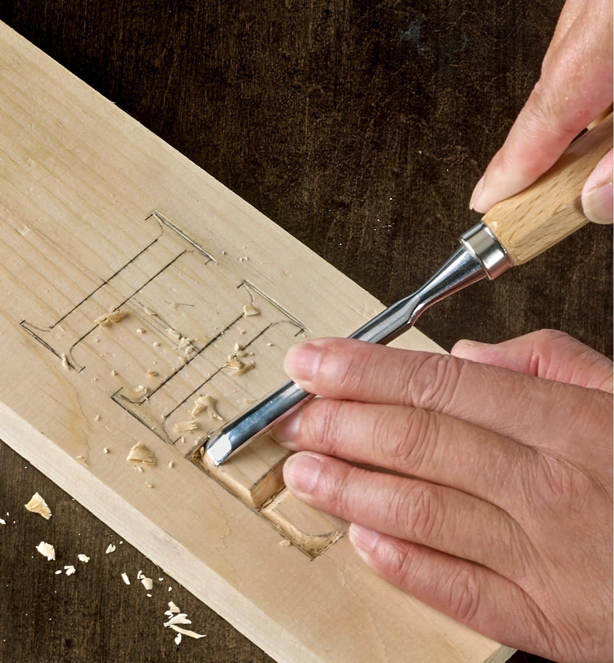 Using a gouge from the seven-piece carving-tool set to incise lettering for a sign-making project