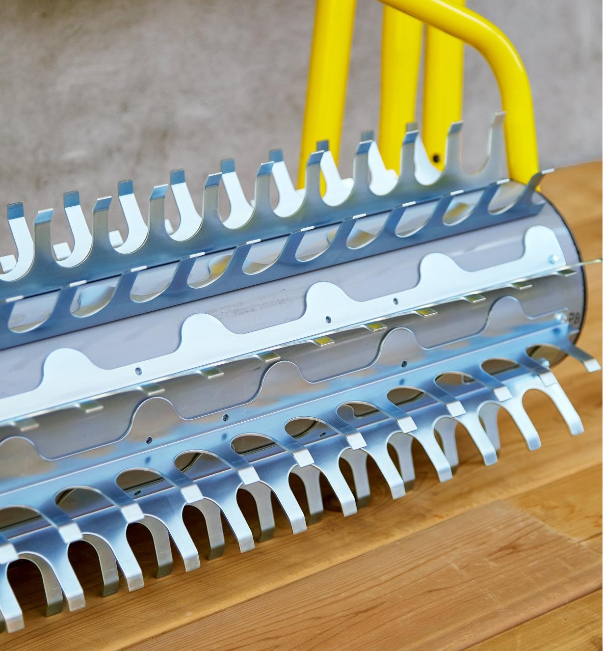 Gros plan des dents en acier galvanisé d'un râteau rotatif pour plan d'eau montrant leur forme de crochet