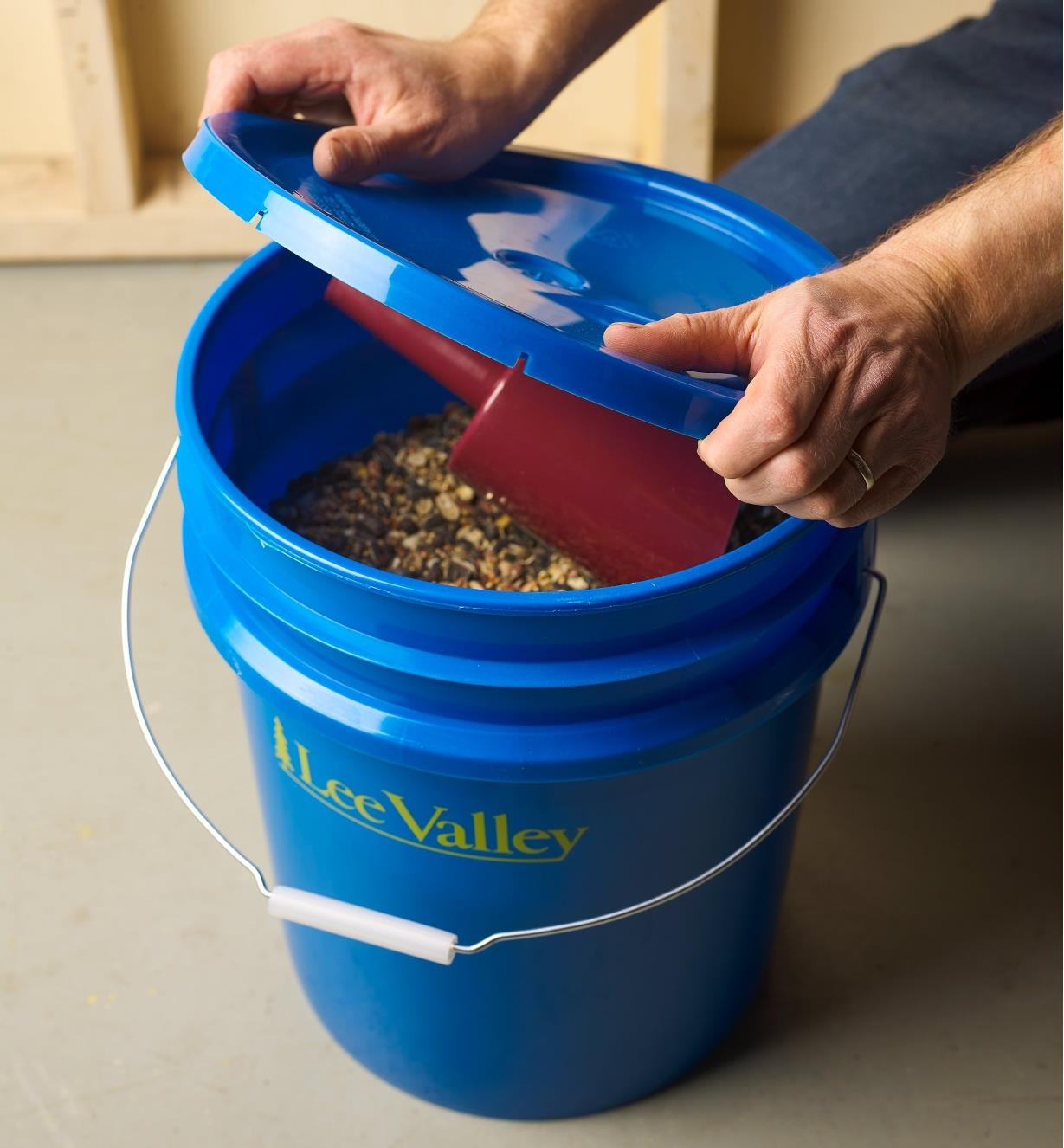 Opening the lid of a 19 Litre Lee Valley Pail filled with birdseed