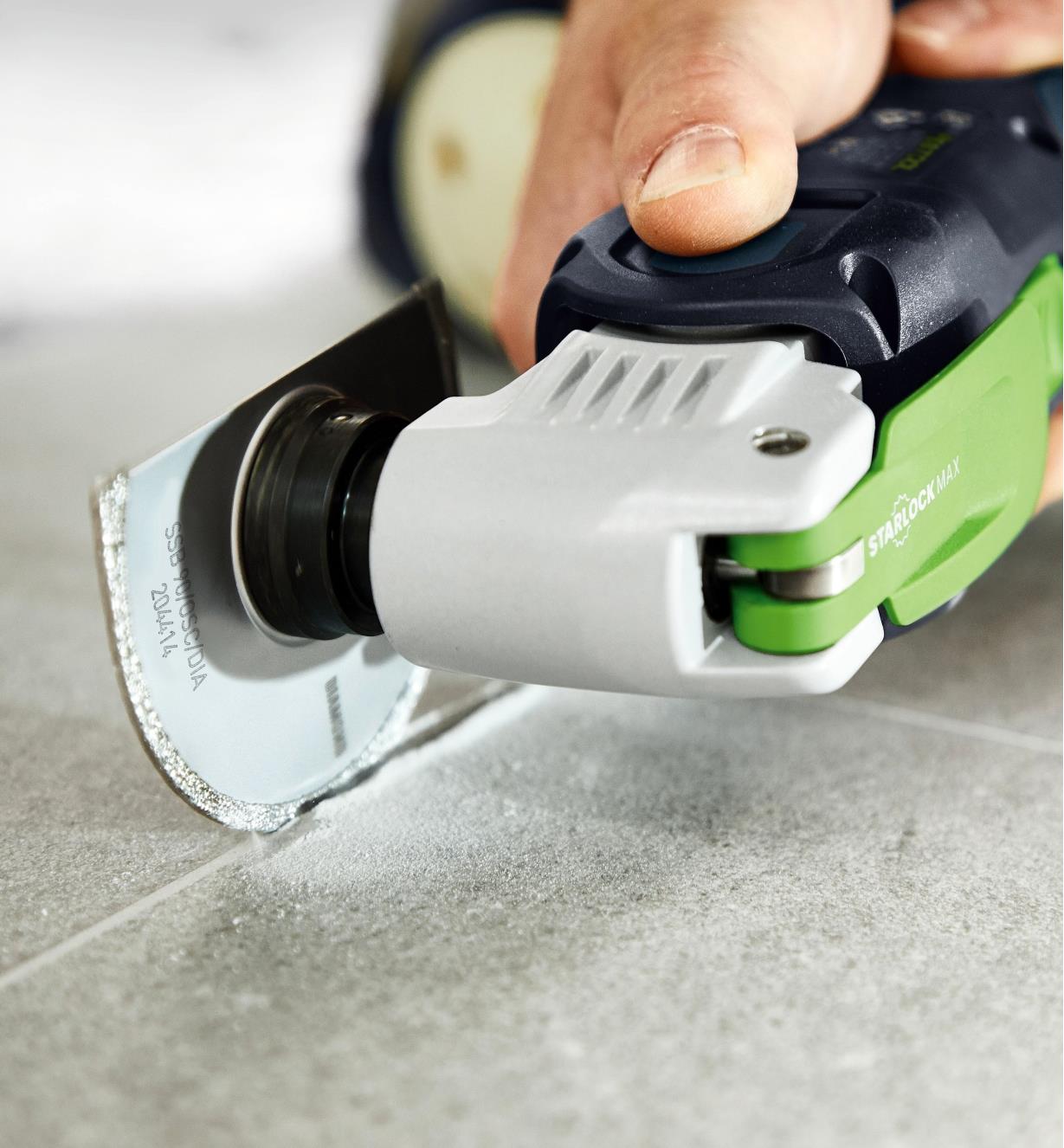 Using an OSC 18 oscillating tool equipped with the diamond saw blade to cut a joint in cement