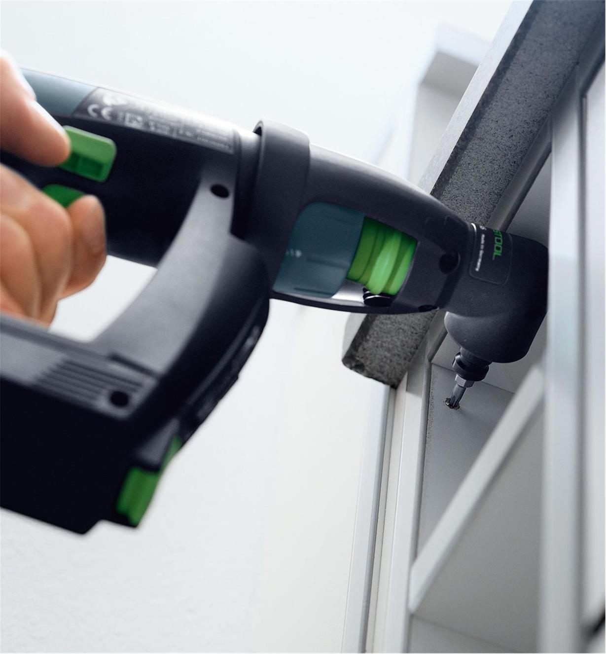 Driving a screw into a cabinet using the right-angle attachment on a CXS Cordless drill