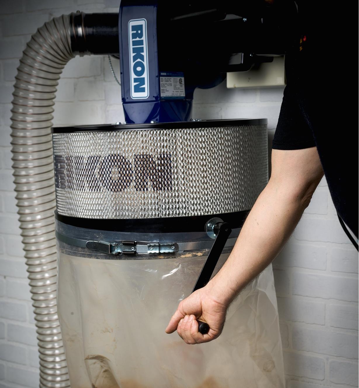 Turning a crank handle on the Rikon 1 hp Wall-Mount Dust Collector