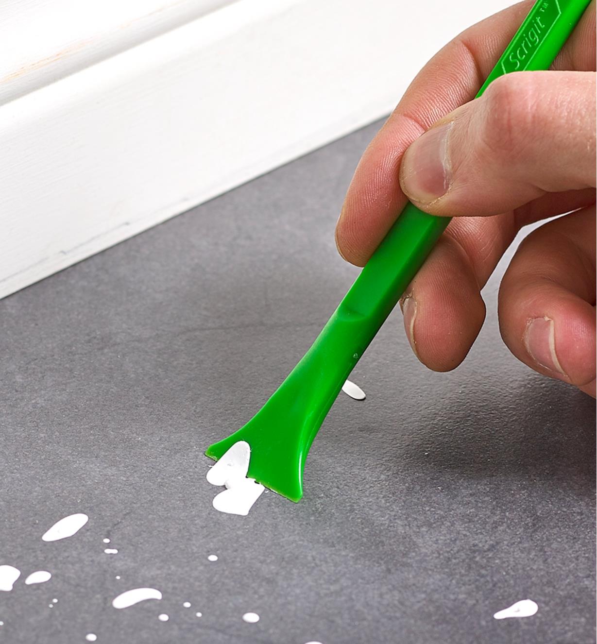 Scraping paint specks from flooring using the wide-blade Scrigit scraper