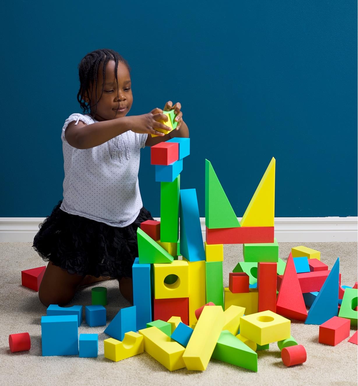 Enfant érigeant une structure avec des blocs de construction anti-éraflures