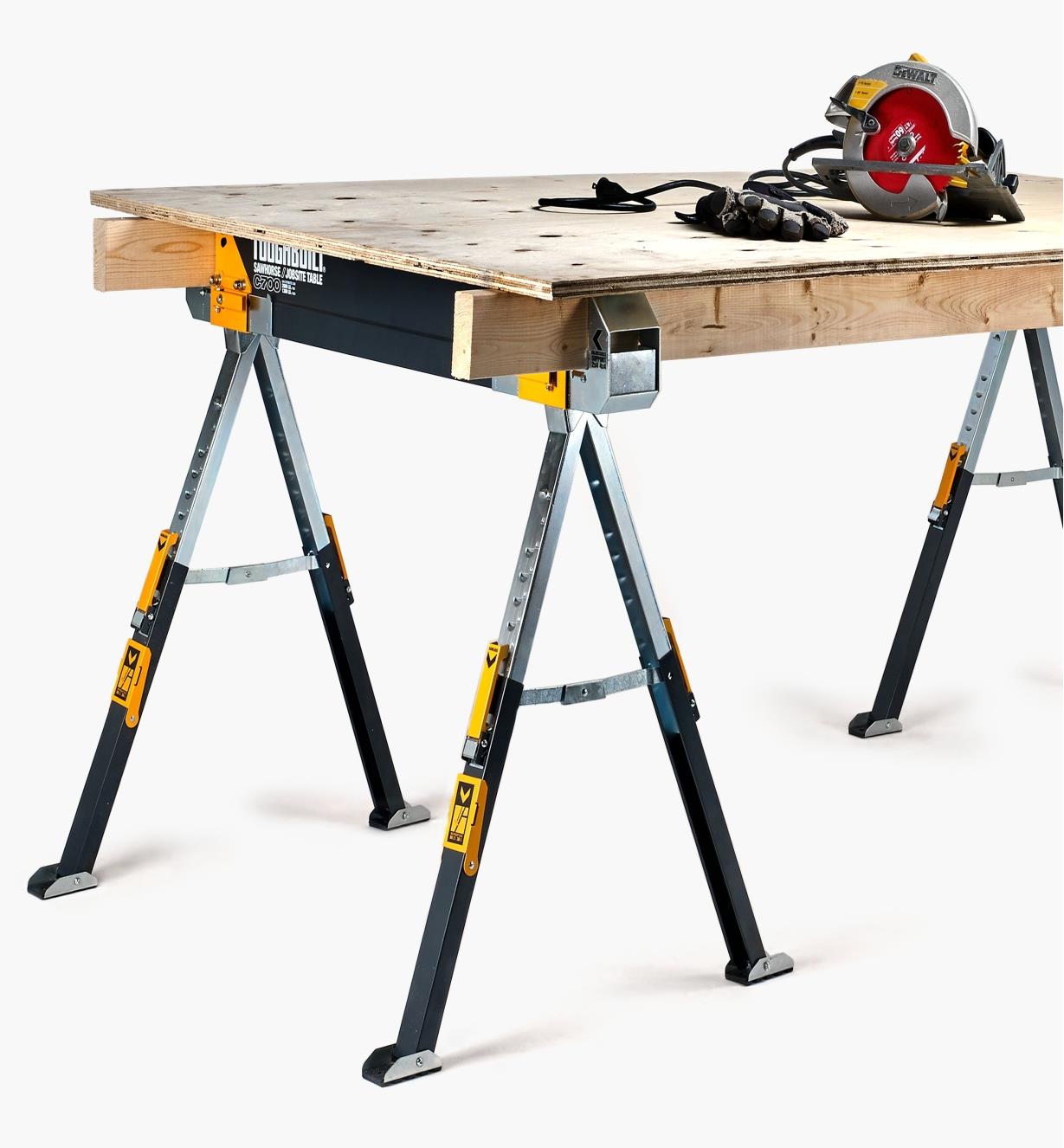 A pair of 2×4s spanning two C700 sawhorses, topped with a sheet of plywood to create a work table