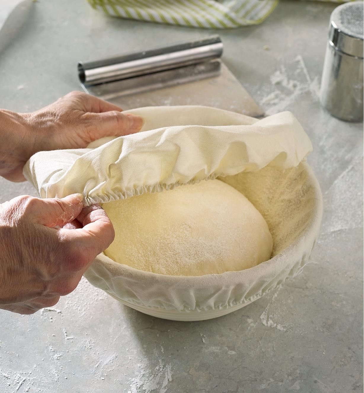 Placing the cover over bread dough set in the lined round banneton