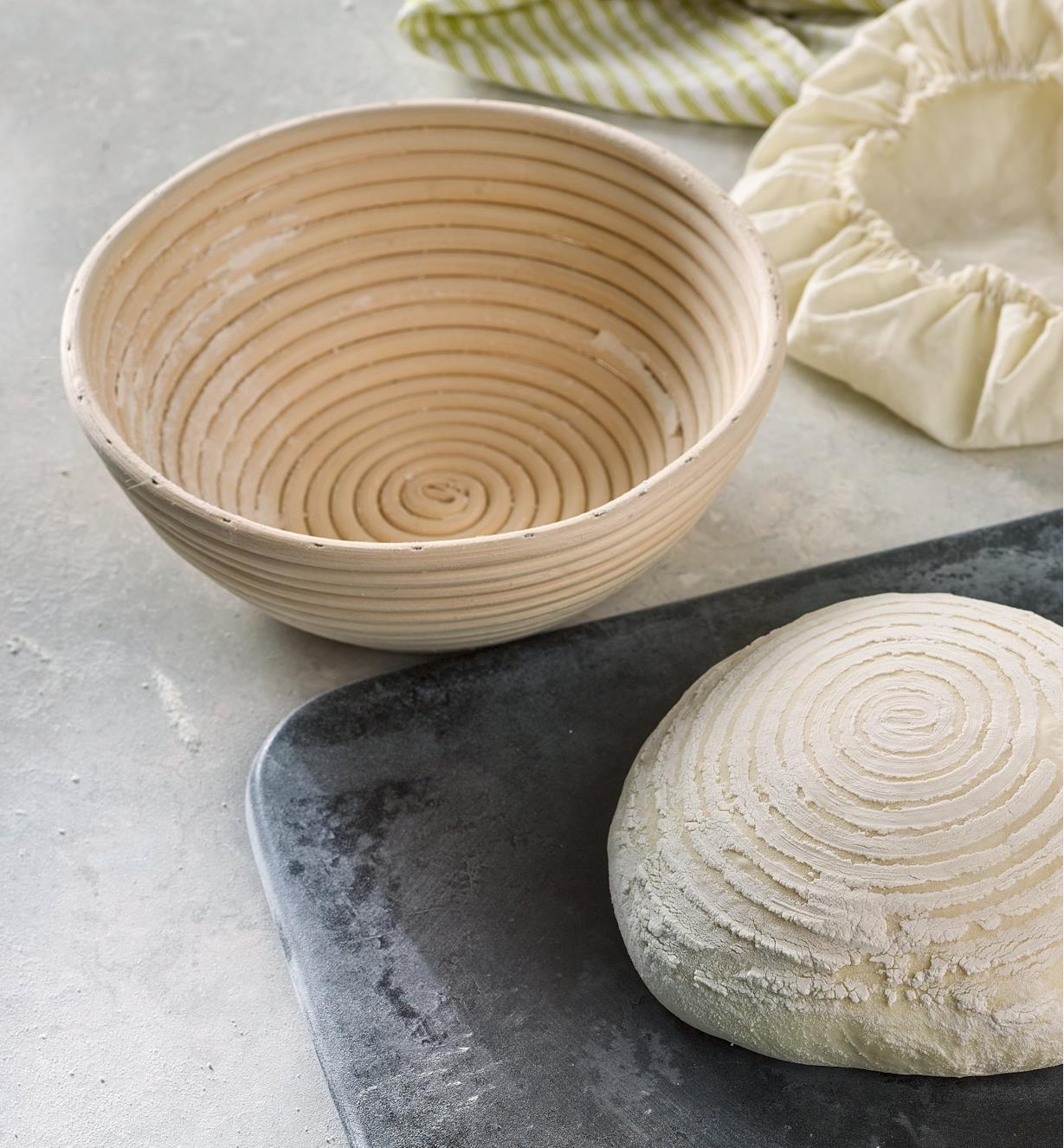 An empty round banneton is shown beside bread dough that is imprinted with the round banneton’s coil pattern