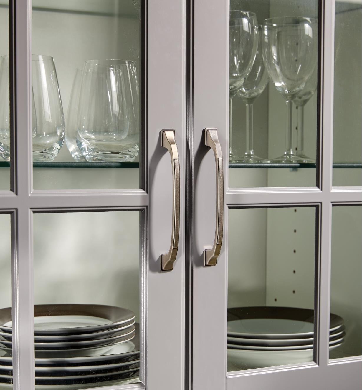 Two 128mm × 24mm pewter Imperia handles mounted on glass cabinet doors