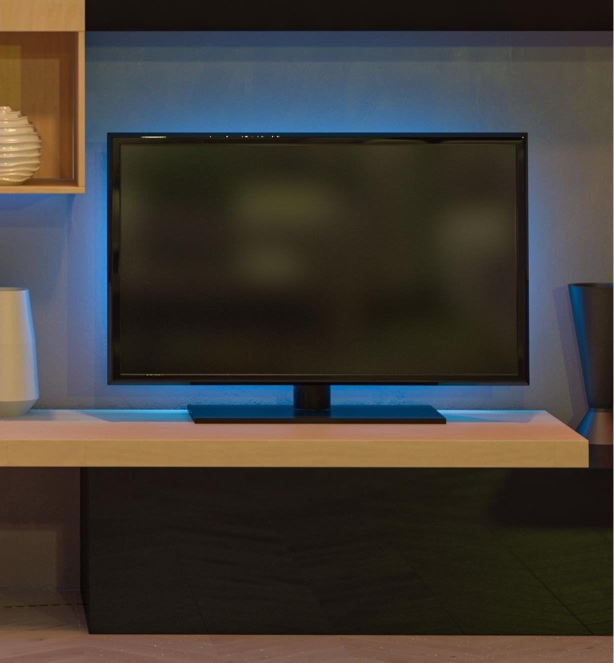 Téléviseur rétroéclairé par un luminaire-ruban réglé à la couleur bleue