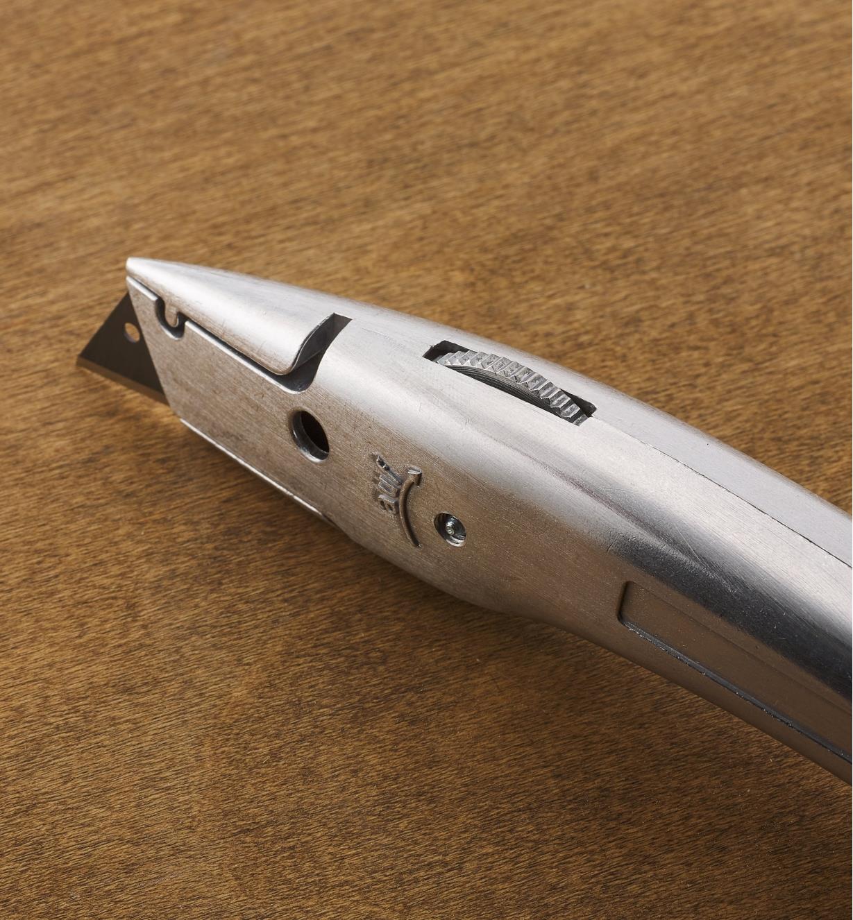 A close-up top view of the Delphin 03 utility knife showing the trapped-wheel blade mechanism
