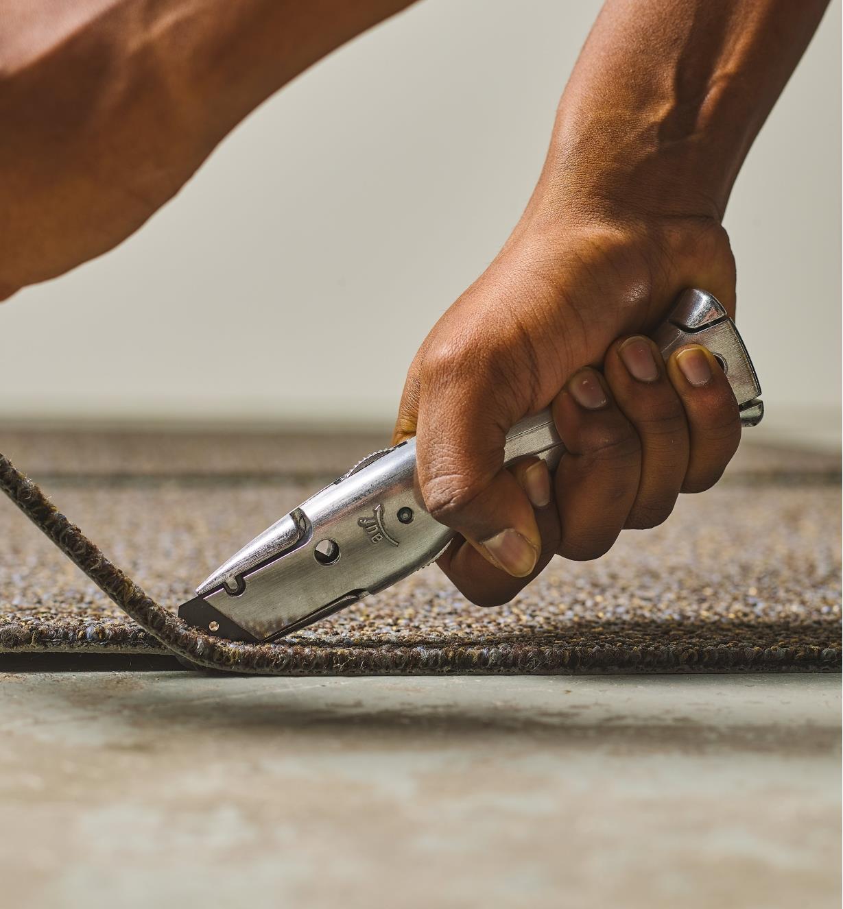 The Delphin 03 utility knife being used to cut carpeting