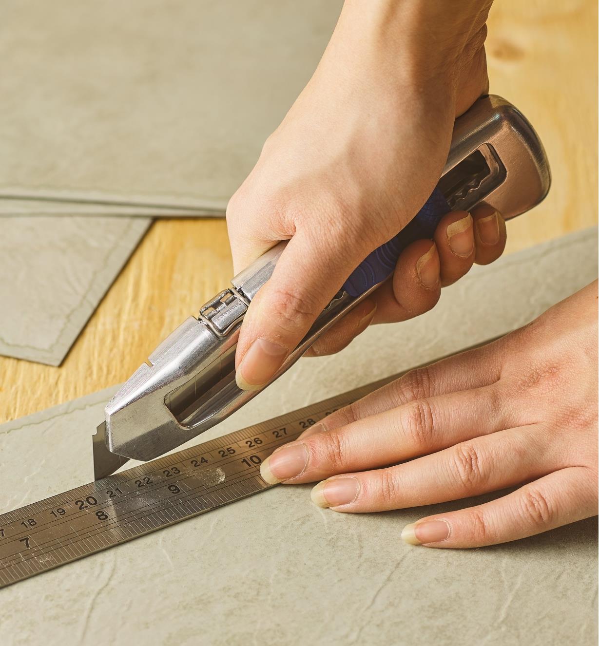 The Delphin snap-off blade knife being used to cut linoleum flooring