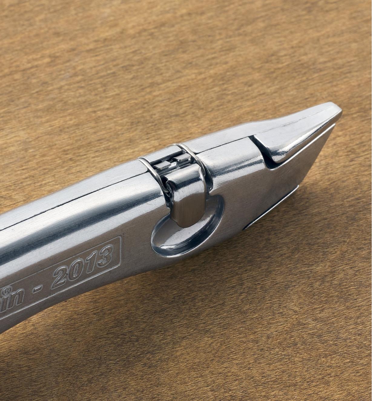 A close-up top view of the Delphin 2013 retractable knife held closed by the draw latch