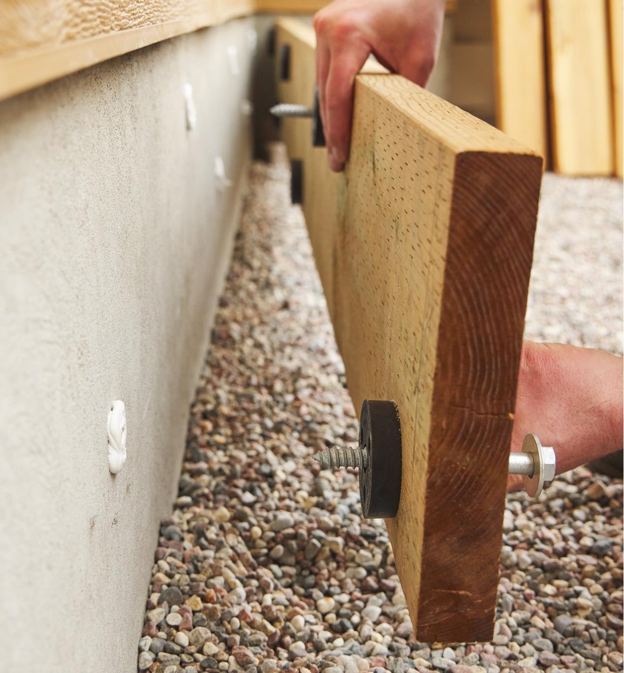 Fastening a ledger and deck-to-wall spacers to a structure using lags