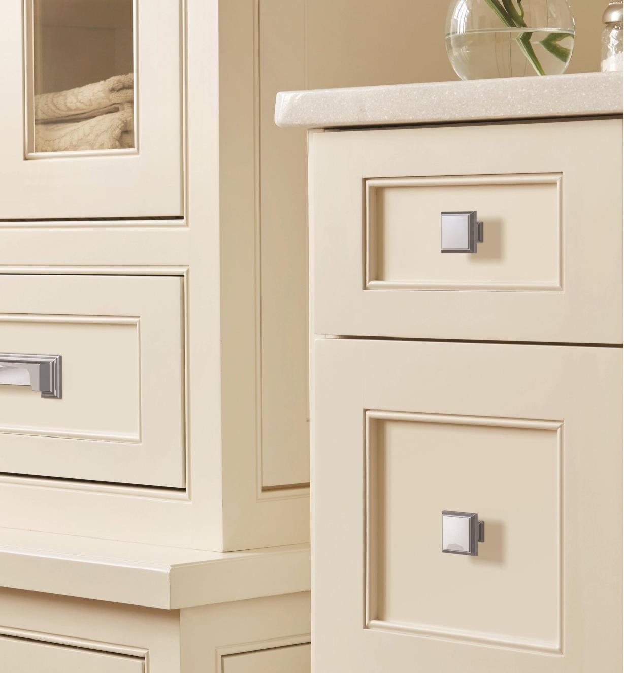Two polished chrome colored Appoint square knobs are connected to two white colored drawers
