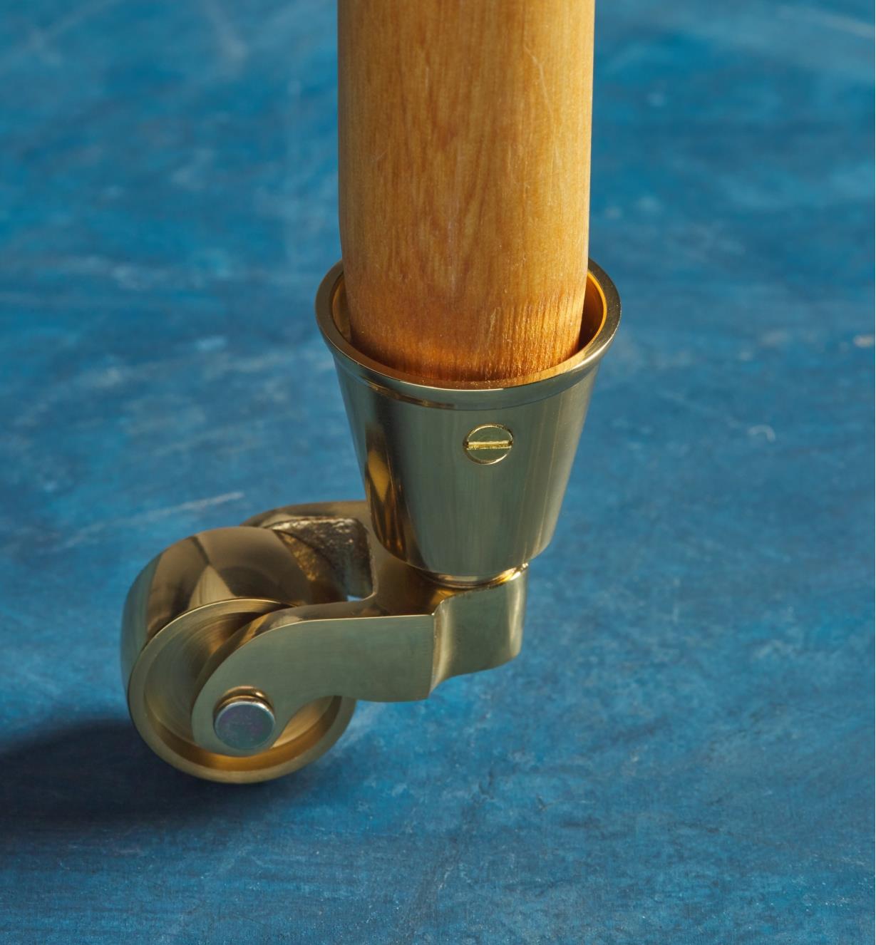 Brass screw used to mount a brass caster to a furniture leg