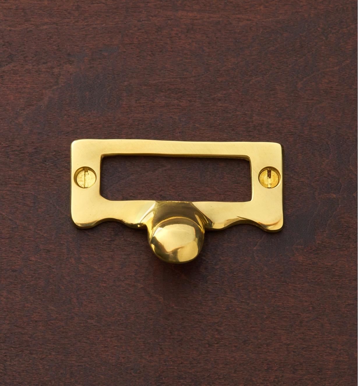 A brass card frame fastened with brass screws