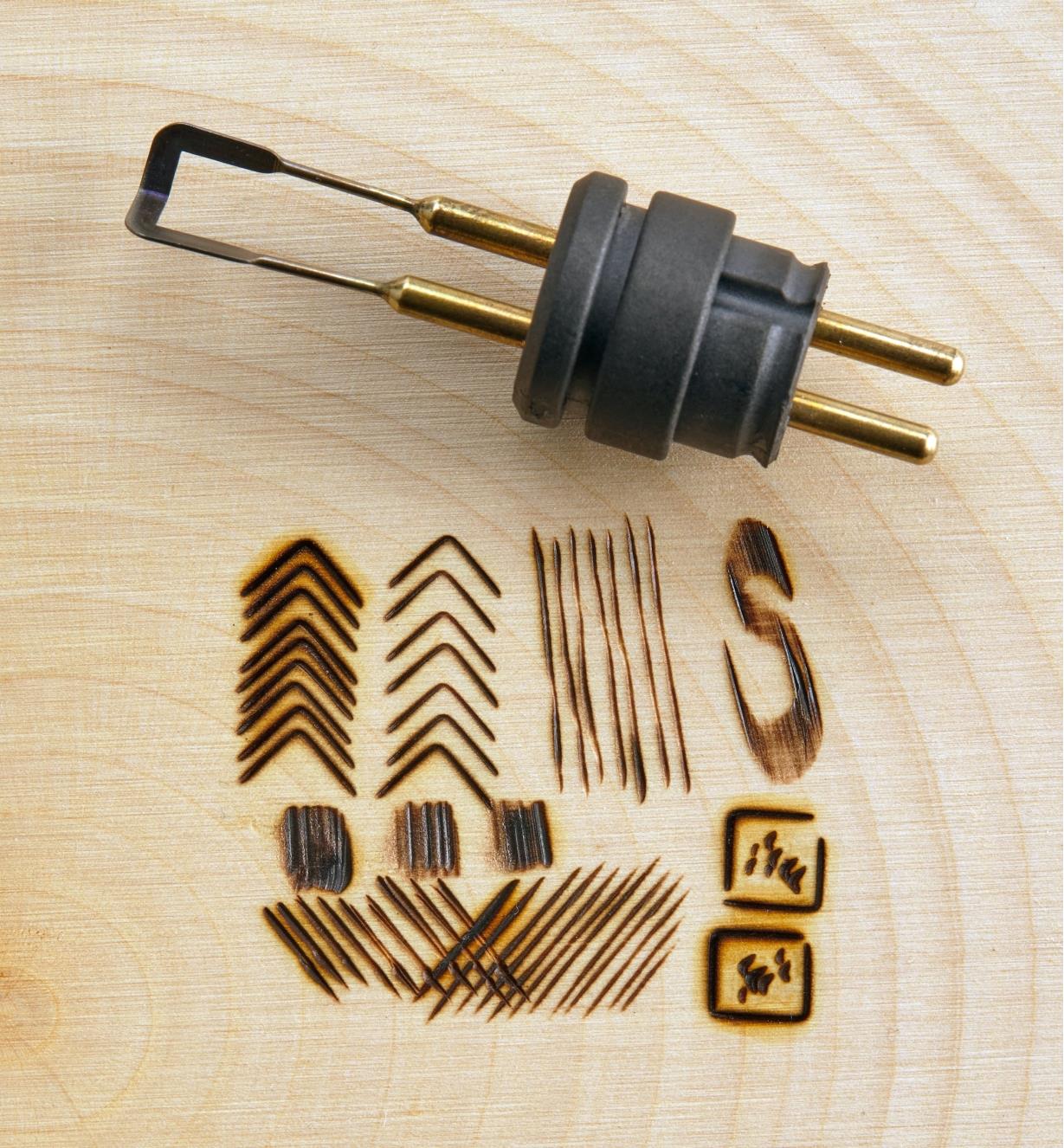 A stamping point tip on a wood background next to geometric burn designs