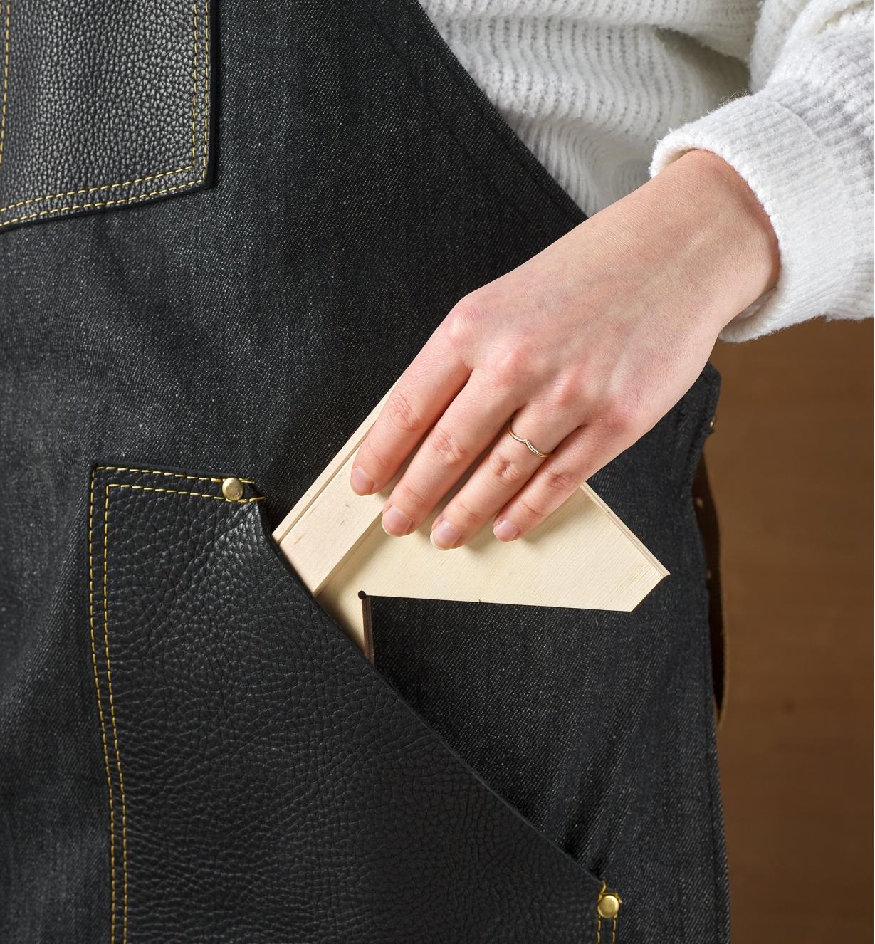A Crucible bench square is placed in the pocket of a black apron