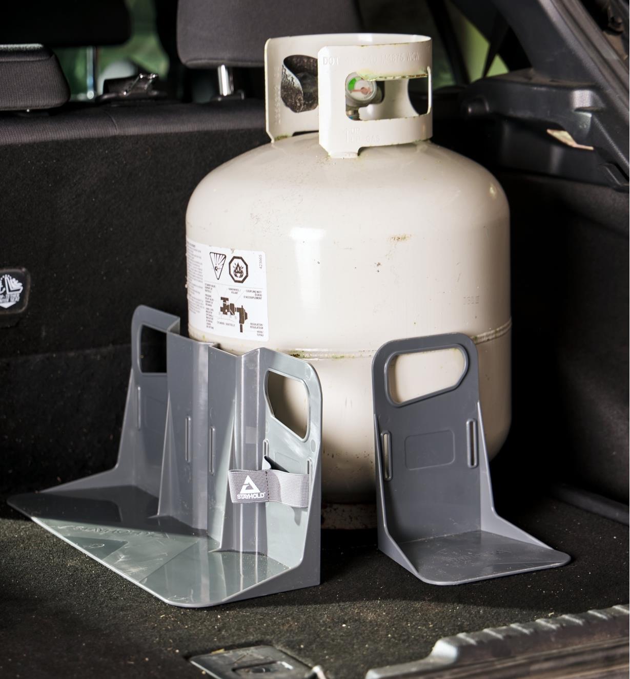 Cargo holder brackets holding a propane tank upright in a car’s cargo area