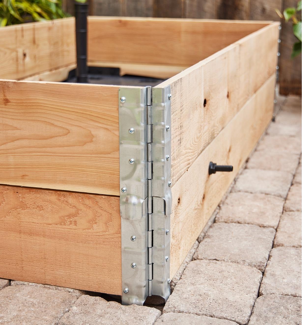 A two-tier wooden frame is built with steel stacking corners from the self-watering raised bed kit