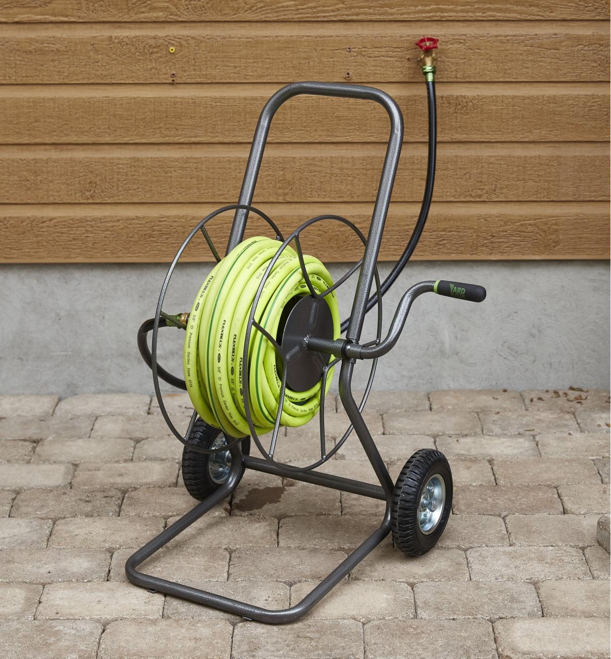 Hose reel cart holding garden hose on a patio