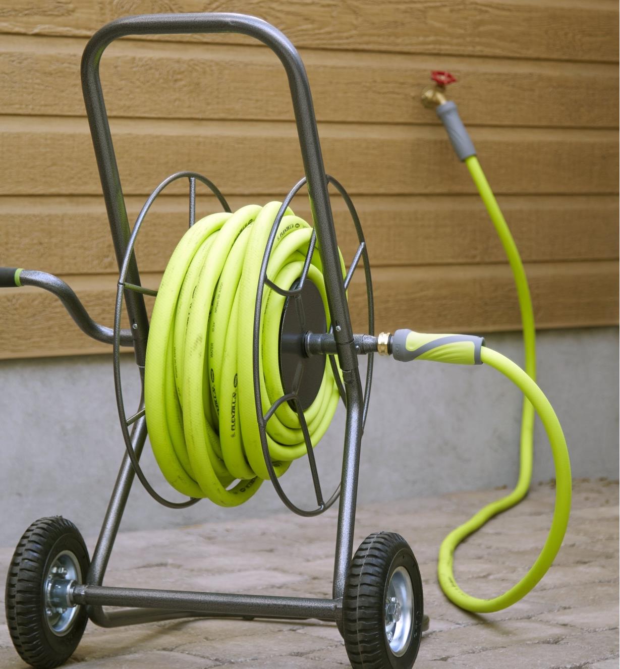 A shorter, bright green leader hose connects to a coiled, longer,  bright green hose