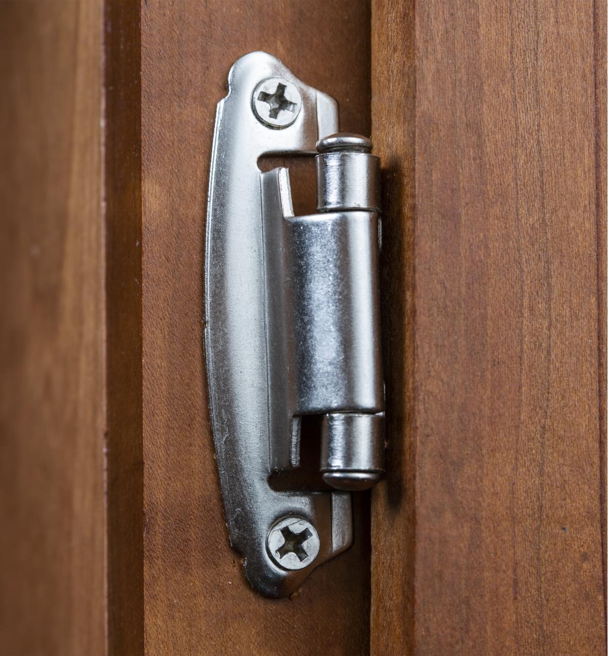 A 2 5/8" self-closing standard hinge installed on a cabinet