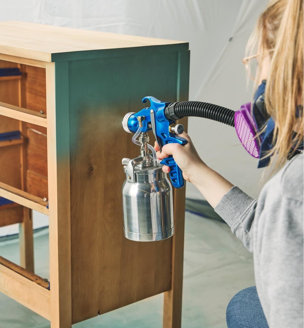 Spraying finish on a wooden chest using the Earlex spray station