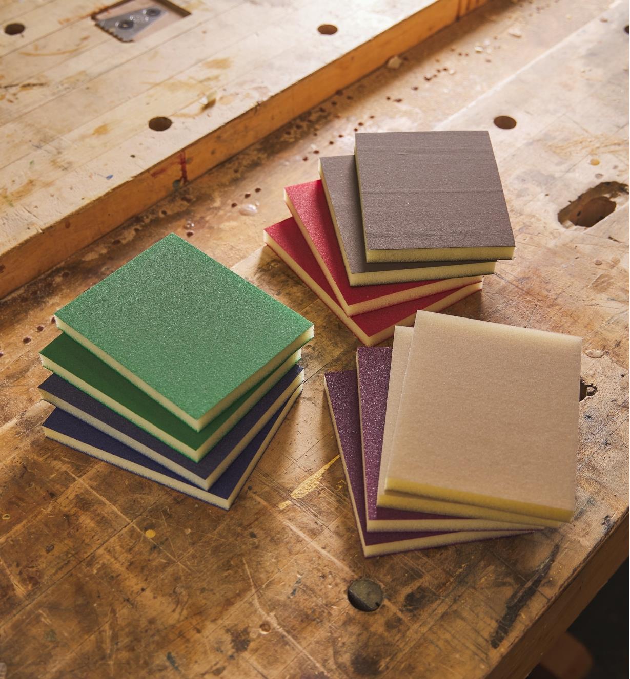 Three stacks of different-colored sponge sheets on a workbench
